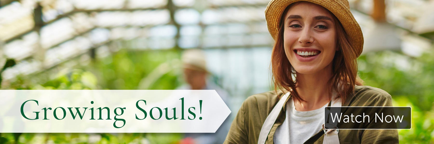 A smiling woman in a greenhouse